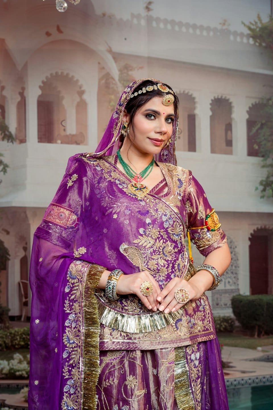 Woman in ornate purple traditional attire with intricate gold jewelry.